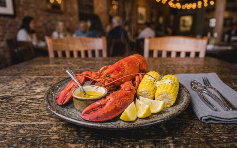 Red Lobster Whole Steamed Maine Lobster (1.25 lb): a whole steamed bright red Maine lobster on a platter with drawn butter, lemon wedges and corn on the cob